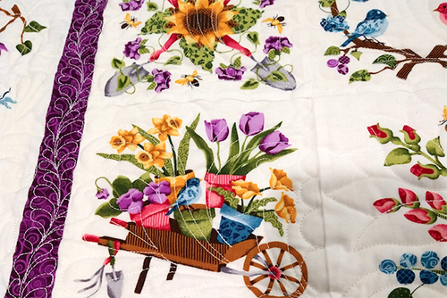 a quilt spread out to show a wagon full of flowers in celebration of spring