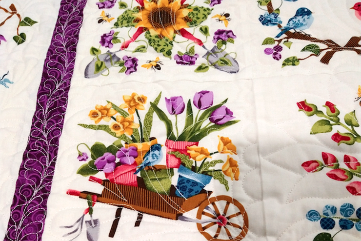 a quilt spread out to show a wagon full of flowers in celebration of spring