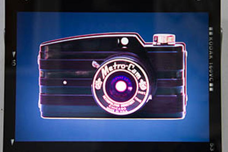 art piece featuring an old fashioned looking camera against a blue background