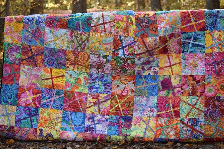 colorful quilts hung up showing all the beautiful squares