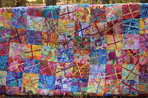 colorful quilts hung up showing all the beautiful squares