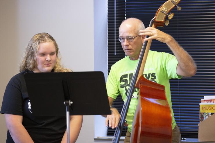 An instructor gives a one on one lesson to a young musician. 