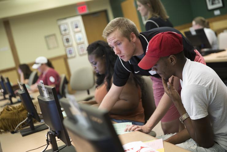 Student workers wearing headsets call alumni on behalf of the University Foundation.