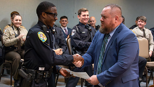 A candidate is congratulated at the Law Enforcement Academy graduation ceremony.