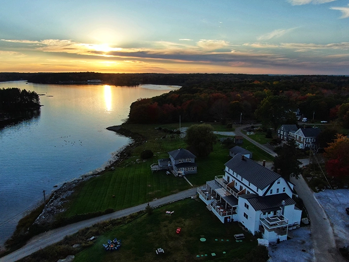 An aerial view of a coastal bed and breakfast at sunset. 