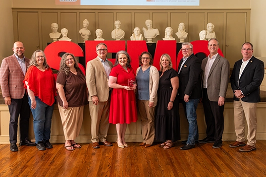 Professionals holding a plaque. 