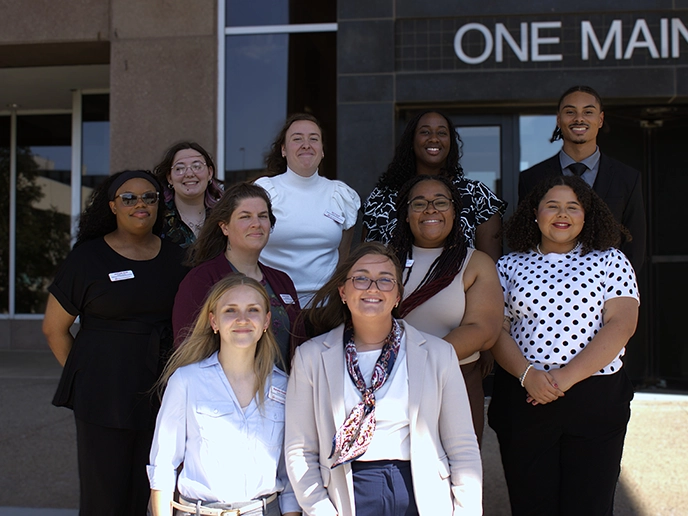 A group of young professionals before an office building.