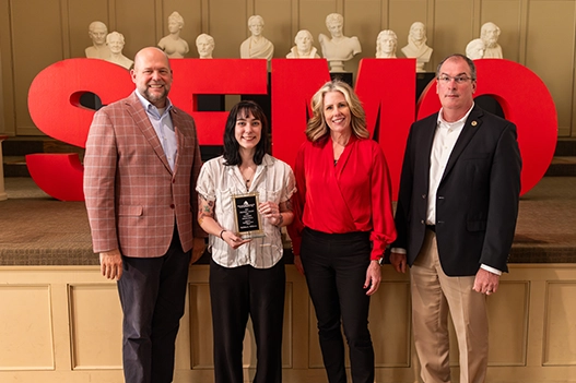 Professionals holding a plaque. 
