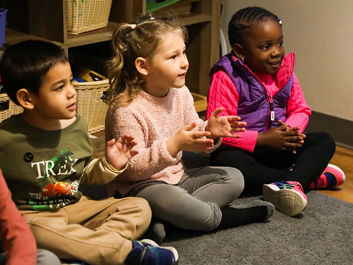 Young children sit patiently at a childcare center.  