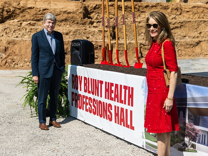 Senator Roy Blunt and wife stand before a stage.