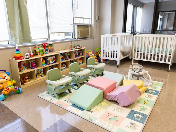 A photo of a room with children's toys and cribs in the Future Leaders Learning Academy.