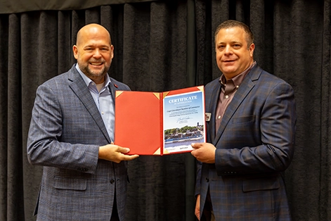A photo of SEMO President Dr. Brad Hodson presenting a Top 5 Small College Town in America award at the Cape Girardeau Chamber's First Friday Coffee.