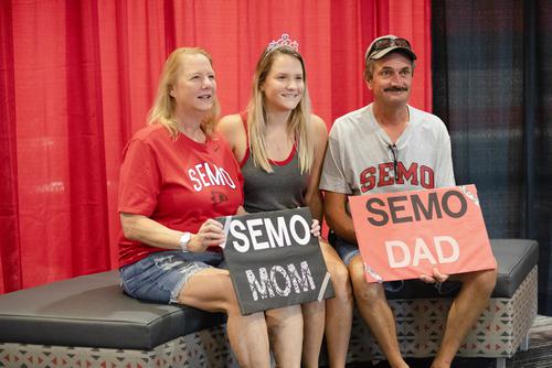 Parents gather with Southeast student holding proud parent signs.