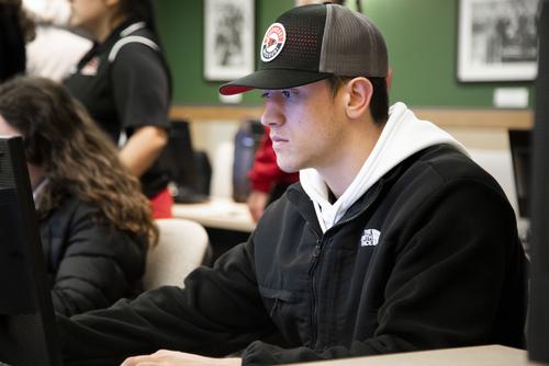 A student at First STEP sits at a computer to register for classes.