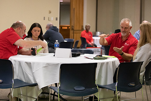Two Southeast Missouri State University First Step staff members talking with students at a table during first step.