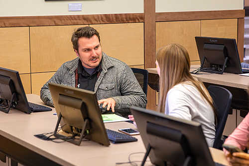 Southeast Missouri State University instructor assisting a student during a computer lab session for first step.