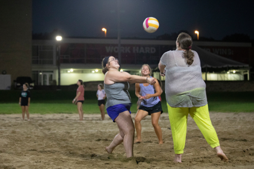 Three students play ultimate volleyball..