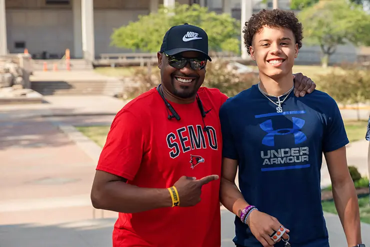 a SEMO student and parent pose for a photo together in front of kent library