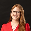 a professionally shot portrait of Sarah Chapmanposed against a red background
