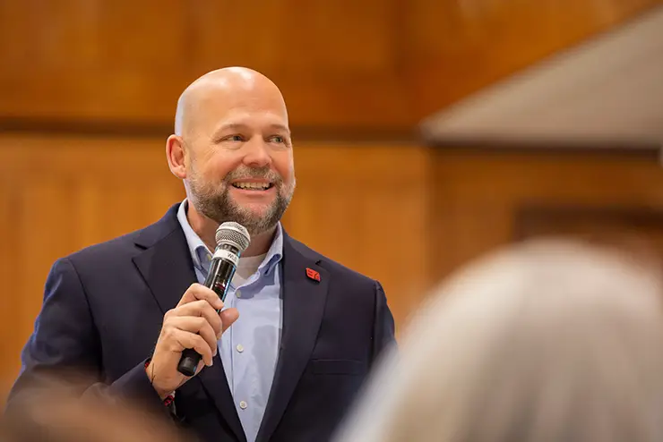 SEMO president Dr Brad Hodson holding a microphone and speaking during an event