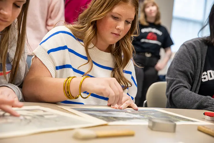 a semo history student participating in what it's like to preserve documents