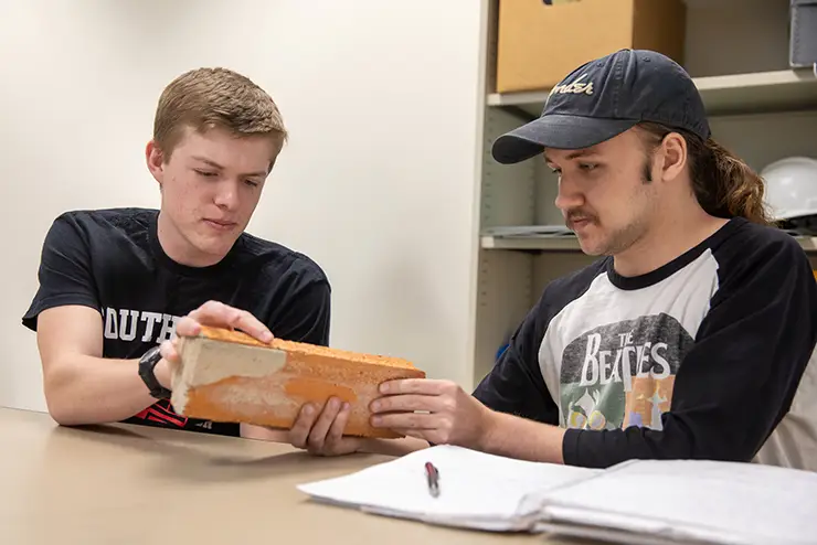 two semo history degree students working together on a piece of historic architecture