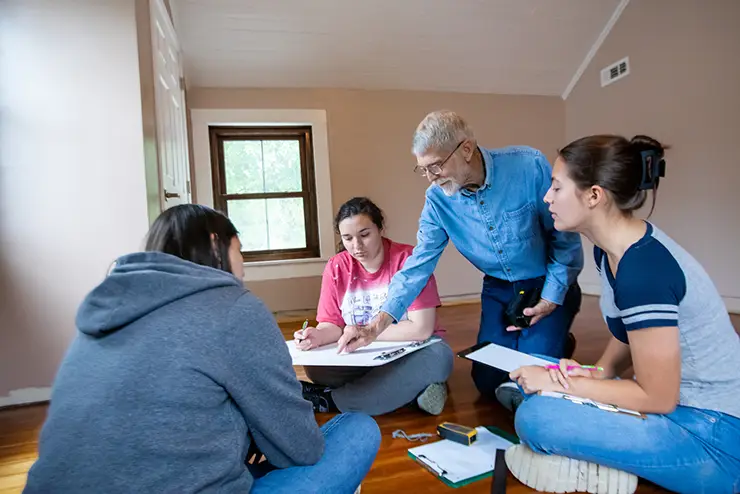 historic preservation students working with a guest instructor on site