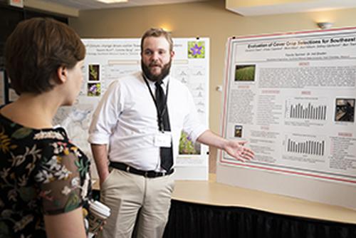 A student presents their research to a faculty member.