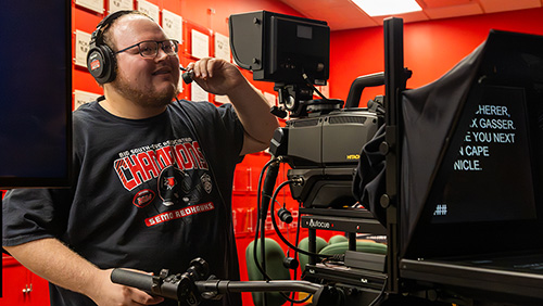 A Mass Media student films a broadcast.