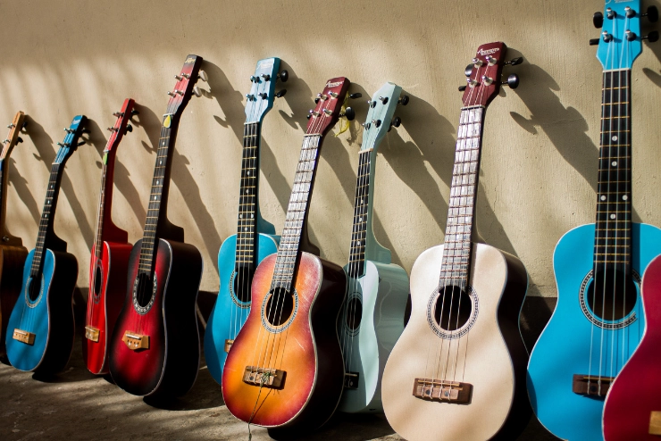 Row of colorful guitars lined up against a wall