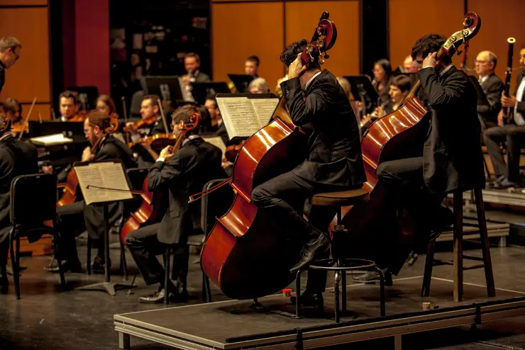 An orchestra performing with a band beside them