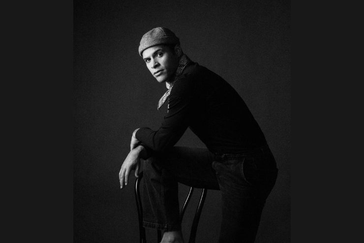Black and white depiction of Leonardo Reyna with one foot propped up on a chair