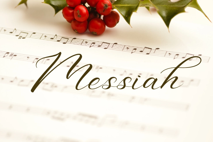 "Messiah" in cursive with a background of a close up of holly on a piece of sheet music