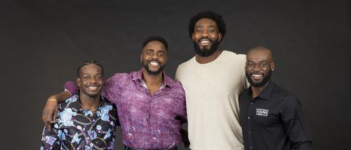 The four alumni founders of the Honorable Young Men's Club smile for the camera.