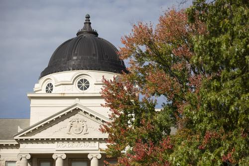 Academic Hall framed by trees turning to fall leaves.