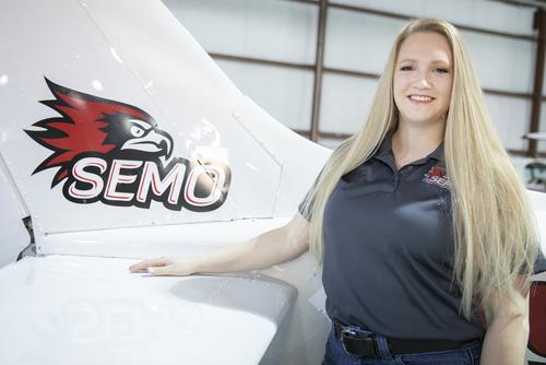 Professor Miranda Sullivan Smiles in front of a SEMO Plane