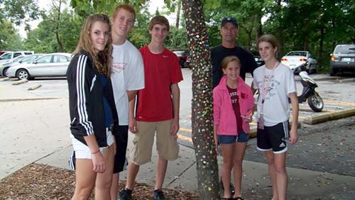 6 members of the Wittich family gather around the Gum Tree, speckled with bits of gum.