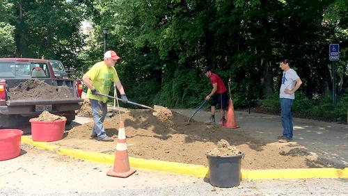 Crews work to prepare the dirt for the third Gum Tree to be planted.