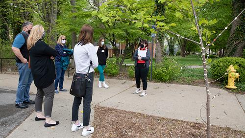 Students and their parents listen as a tour guide talks about the Gum Tree.