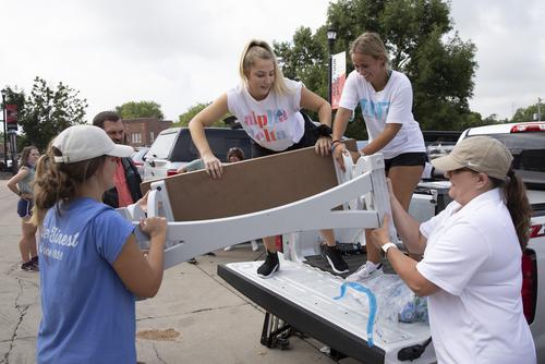 students taking boxes of a truck