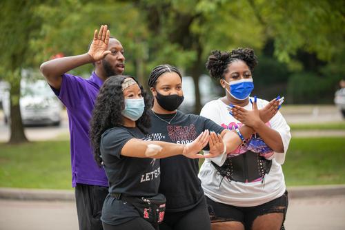 students putting up greek signs with their hands