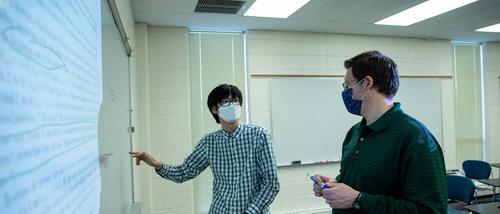 Dr. Daniel Daly and Samuel Hwang discuss a research paper.