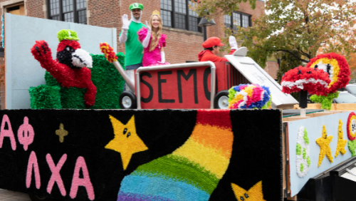 Students ride in a parade float dressed as video game characters.