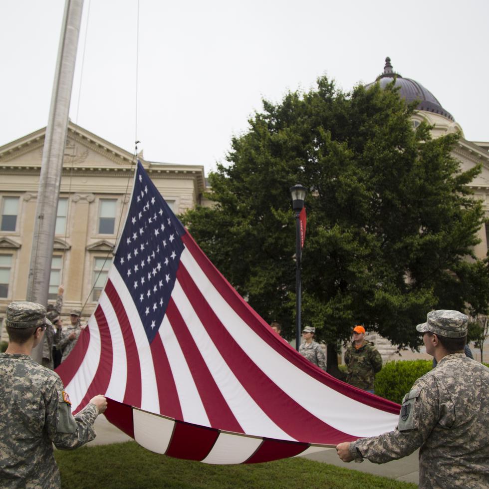 Members of the military assist with the lowering of the American flag