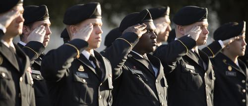 Military members salute during flag ceremony