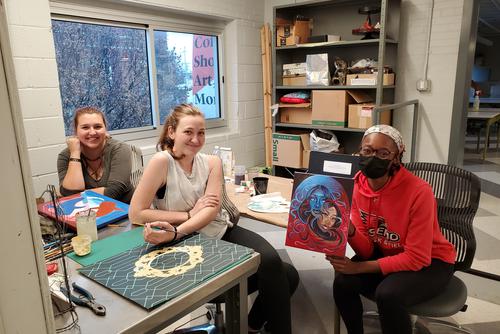 Students sit at a desk collaborating at Catapult.