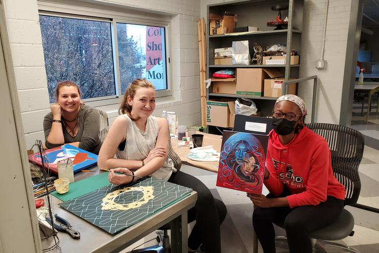 Students sit at a desk collaborating at Catapult.