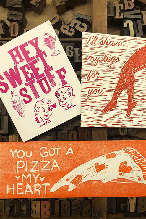 hand printed valentines cards spread out on top of movable type cases