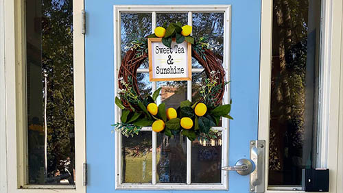 a handmade wreath hung on a blue door for display
