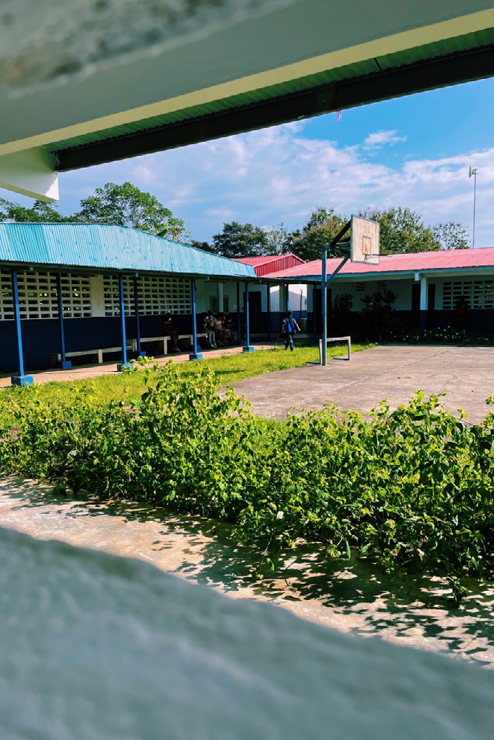 The courtyard between to colorful buildings. A basketball court takes up a majority of the courtyard.